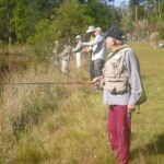 Members on a private dam removing excess silver perch
