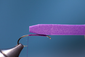 Trim end of foam strip to a taper. Next, place foam strip on top of hook as shown above and mark the foam with your fingernail just beyond the hook eye.