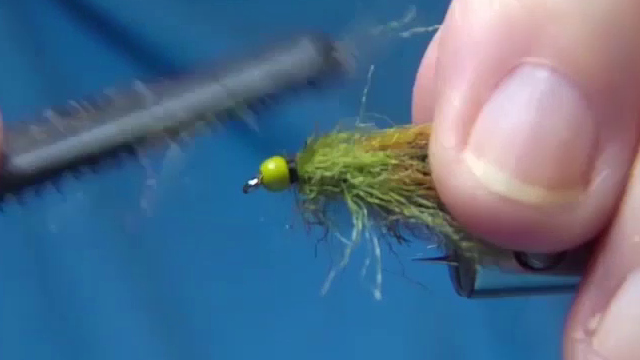 Tie off the dubbing near the bead and whip finish.
Use a comb or brush to tease out the fibres, brushing the body up and back.