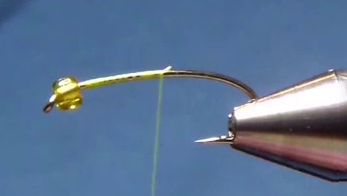 A curved size 12 hook with a clear green plastic bead slid to the eye. A smooth base of sheer green thread is wrapped along the hook shank.