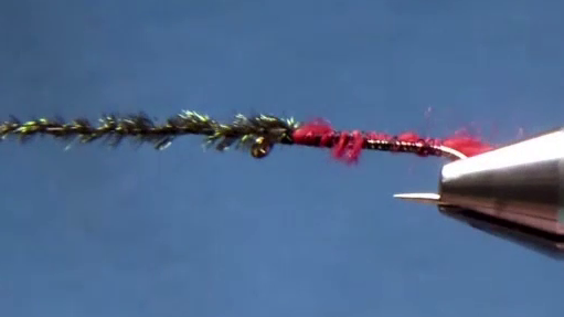 Silver tinsel tied in along the shank with several strands of peacock herl prepared at the hook eye, ready to form the body.