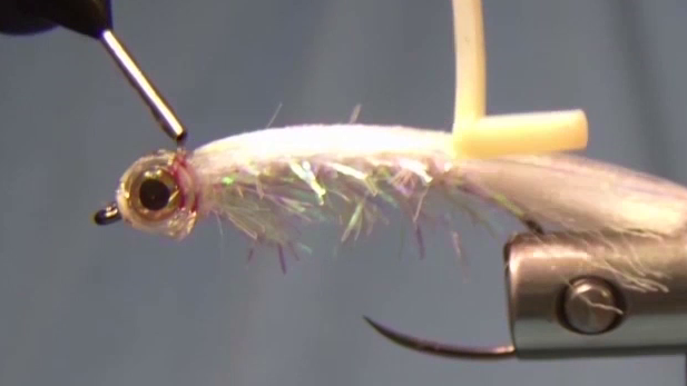 Additional UV resin being applied to fill the back of the fish mask, with slight red tint visible as the thread color bleeds into the resin.