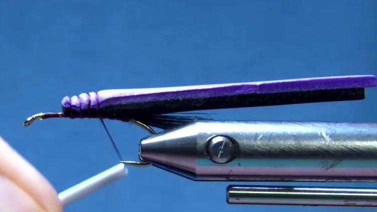 Makeup-brush fibres are tied in to form the tail, and two foam body strips are secured on top of the hook shank.