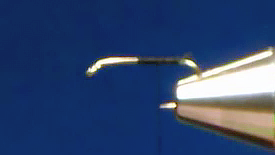 Hook secured in vise with thread base laid along shank for body assembly