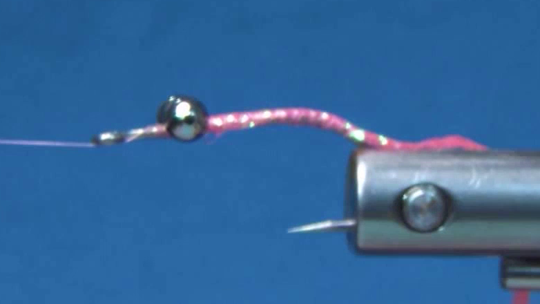 Bright pink FTD FF Braid tied in and wrapped forward to form a smooth, tapered body behind the bead chain eyes.