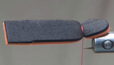 Orange foam tied in over the hook bend, orange side facing down.